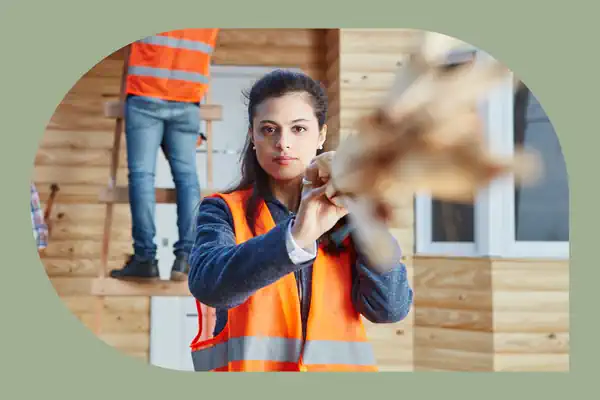 woman working on a construction site wearing orange safety vest